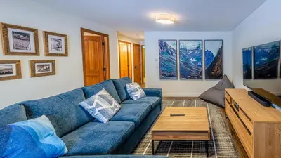 a living room with a blue couch and a wooden coffee table at Trails Edge #25 By Bear Country in Sun Peaks