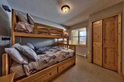 a bedroom with two bunk beds and a window at Crystal Forest #40 By Bear Country in Sun Peaks