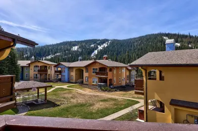 a group of houses with a mountain in the background at Crystal Forest #22 By Bear Country in Sun Peaks