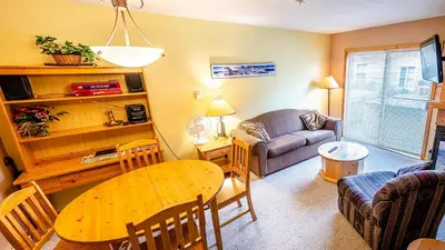 a living room with a table and a couch at Crystal Forest #04 By Bear Country in Sun Peaks