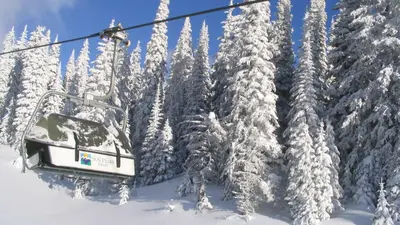 a ski lift with snow covered trees at Stones Throw #12 By Bear Country in Sun Peaks