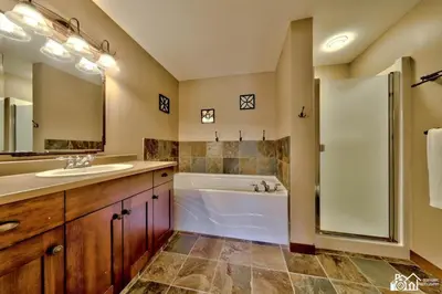 a bathroom with a tub and a sink and a shower at Stones Throw #12 By Bear Country in Sun Peaks