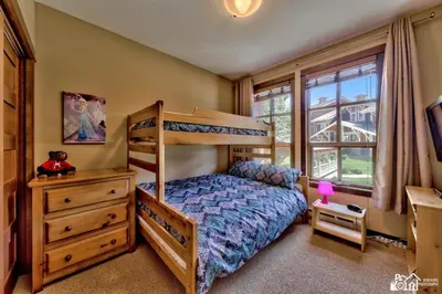 a bedroom with a bunk bed and a dresser at Stones Throw #12 By Bear Country in Sun Peaks
