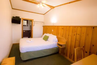 a bedroom with a bed and a desk and a table at Gateway Motel in Radium Hot Springs