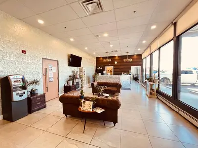 a living room with a couch and a table at Camrose Le Chateau Hotel in Camrose