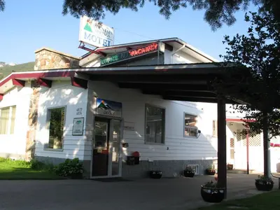 a white building with a sign that reads motel at Mountain Springs Motel in Radium Hot Springs