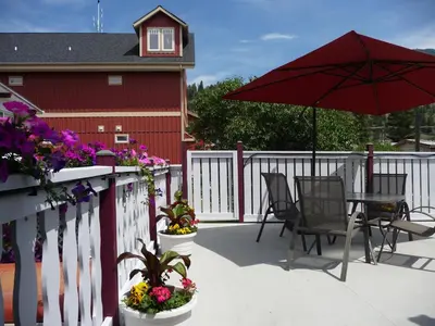 a patio with a table and chairs and an umbrella at Mountain Springs Motel in Radium Hot Springs