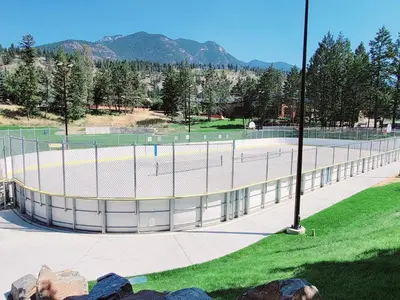 a tennis court in a park with mountains in the background at Mountain Springs Motel in Radium Hot Springs