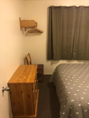 a bedroom with a bed and a table and a window at Mountain Springs Motel in Radium Hot Springs