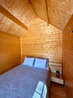 a bedroom of a wooden cabin with a bed at Garden Bay Hideaway - Glamping & RV in Garden Bay