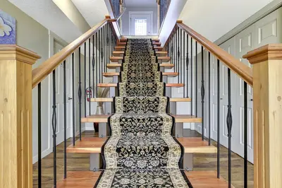 a staircase in a house with a rug on it at Rodee Homestay in West Kelowna