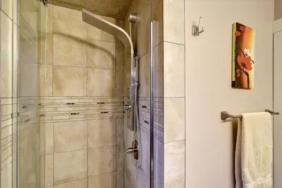 a shower with a glass door in a bathroom at Rodee Homestay in West Kelowna