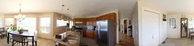 a kitchen with a stainless steel refrigerator and a table at Rodee Homestay in West Kelowna