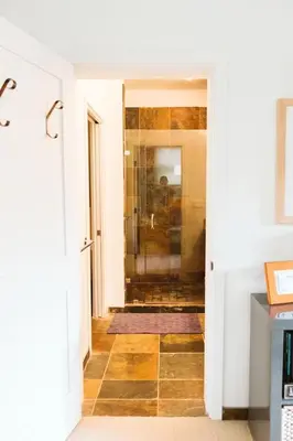 a bathroom with a shower with a tile floor at Pacific Soul Eco-Luxe Vacation Home in Ucluelet