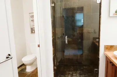 a bathroom with a shower with a toilet at Pacific Soul Eco-Luxe Vacation Home in Ucluelet