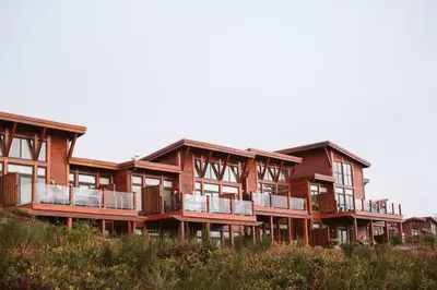 a large wooden building with balconies on top of a field at Pacific Soul Eco-Luxe Vacation Home in Ucluelet