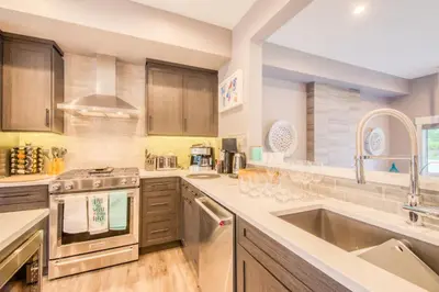 a kitchen with stainless steel appliances and wooden cabinets at Nomad by Samsara Resort - Panorama Top View - 4BR & 5BTH in Canmore