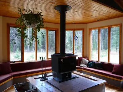 a living room with a stove in the center of the room at HI Castle Mountain - Hostel in Castle Junction