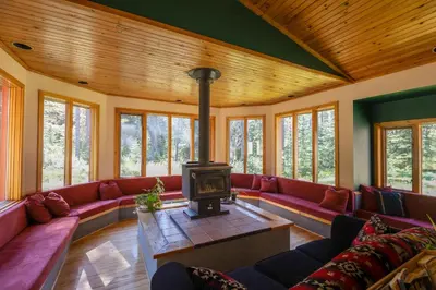 a living room with red couches and a fireplace at HI Castle Mountain - Hostel in Castle Junction