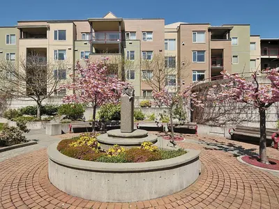 a park with a statue in front of a building at Deluxe 2 Bed 2 Bath With Harbour And Empress Hotel Views in Victoria