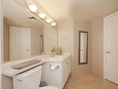 a bathroom with a sink and a toilet and a mirror at Deluxe 2 Bed 2 Bath With Harbour And Empress Hotel Views in Victoria