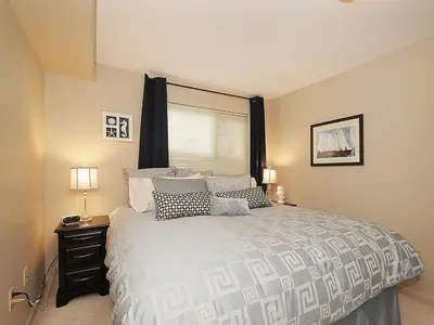 a bedroom with a large bed and a window at Deluxe 2 Bed 2 Bath With Harbour And Empress Hotel Views in Victoria