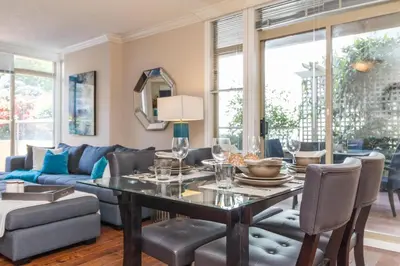 a living room with a table and a couch at 5 Min Walk To Famous Victoria Inner Harbour And Empress Hotel in Victoria