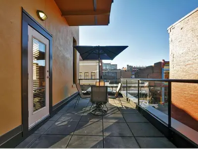 a balcony with a table and an umbrella at Gorgeous Luxury 2 Bedroom 2 Bath Condo In Old Town Victoria in Victoria