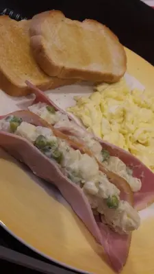 a plate of food with ham eggs and toast at Vancouver Traveller B&B in Vancouver