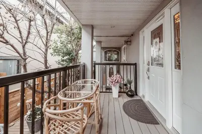 a porch with two chairs and a door on a house at Along River Ridge in Calgary