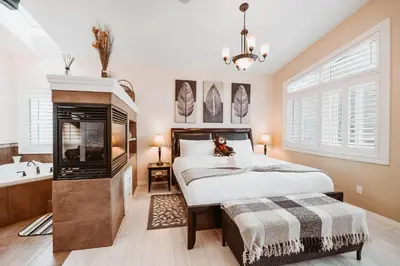 a bedroom with a large bed and a bath tub at Along River Ridge in Calgary