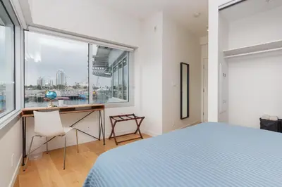 a bedroom with a bed and a desk and a window at Enjoy The Waterway Action At Your Doorstep in Victoria