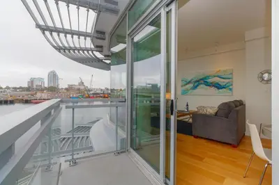 a living room with a balcony with a view of the city at Enjoy The Waterway Action At Your Doorstep in Victoria