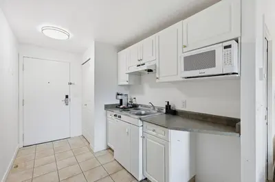 a white kitchen with a sink and a microwave at Lillooet Hotel Victoria in Lillooet