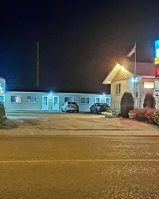 a gas station at night with cars parked in front at Vista Motel in Vegreville