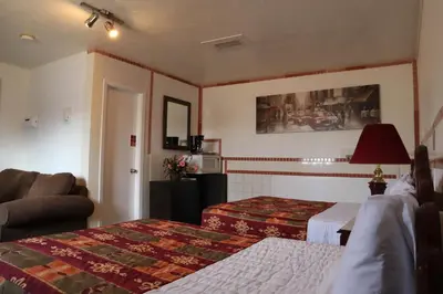 a hotel room with two beds and a couch at Vista Motel in Vegreville