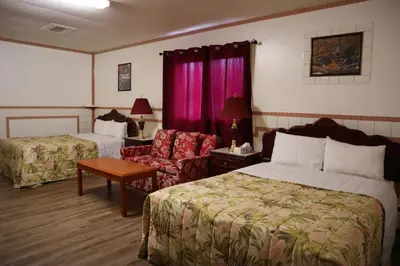 a hotel room with two beds and a chair at Vista Motel in Vegreville