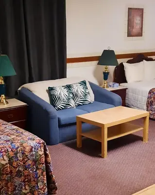 a hotel room with a couch and a bed at Vista Motel in Vegreville