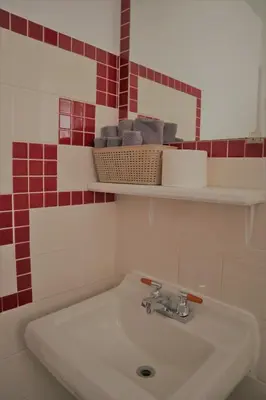a white sink in a bathroom with red tiles at Vista Motel in Vegreville