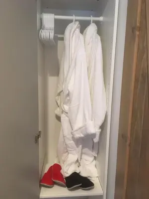 a closet filled with white towels and red shoes at Oceanspray Hideaway in North Saanich