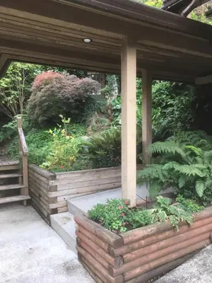 a screened in porch with flowers and plants at Oceanspray Hideaway in North Saanich