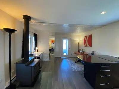 a living room with a stove and a dining room at Woodhouse Cottages And Ranch in Prince George