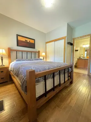 a bedroom with a large bed with a wooden frame at Casa Del Mila Oro Condo in Osoyoos