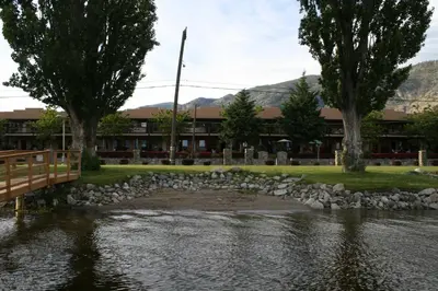 a bridge over a river with a building in the background at Casa Del Mila Oro Condo in Osoyoos
