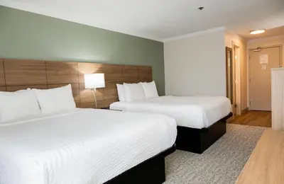 a hotel room with two beds with white sheets at Quality Inn & Suites in Whitehorse