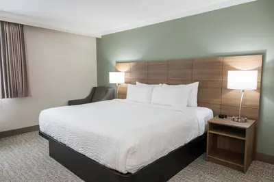 a hotel room with a large bed and a chair at Quality Inn & Suites in Whitehorse