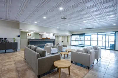 a waiting area with chairs and tables in a lobby at Quality Inn & Suites in Whitehorse
