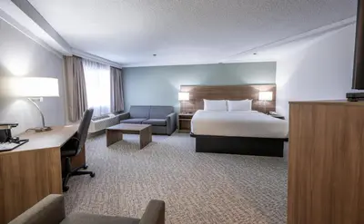 a hotel room with a bed and a desk at Quality Inn & Suites in Whitehorse