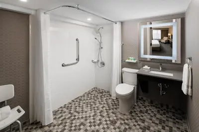 a bathroom with a toilet and a sink and a shower at Pomeroy Hotel & Conference Centre in Grande Prairie