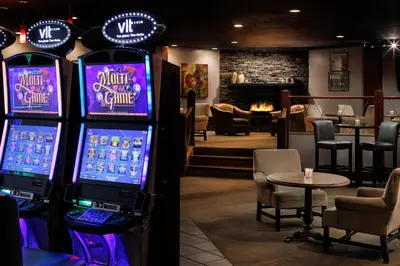 a room with two video game machines and a table at Pomeroy Hotel & Conference Centre in Grande Prairie